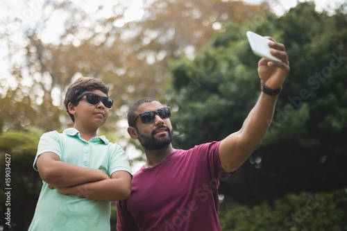 Father taking selfie with son at park