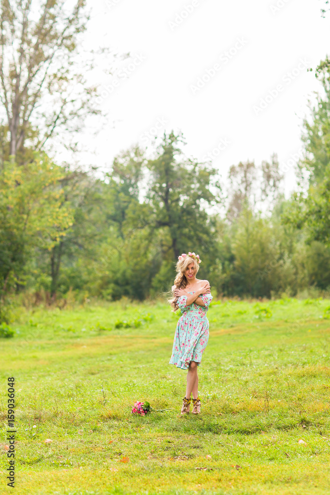 Fototapeta premium Portrait of the young beautiful romantic woman in dress outdoors