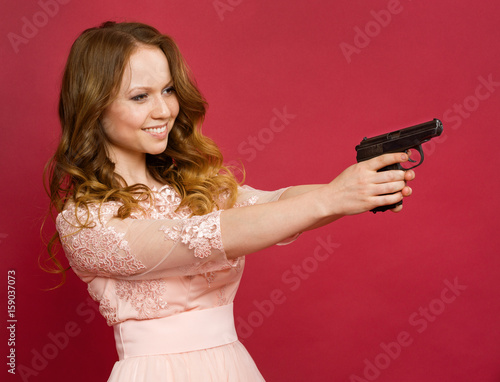 Girl posing with a gun on a colored background