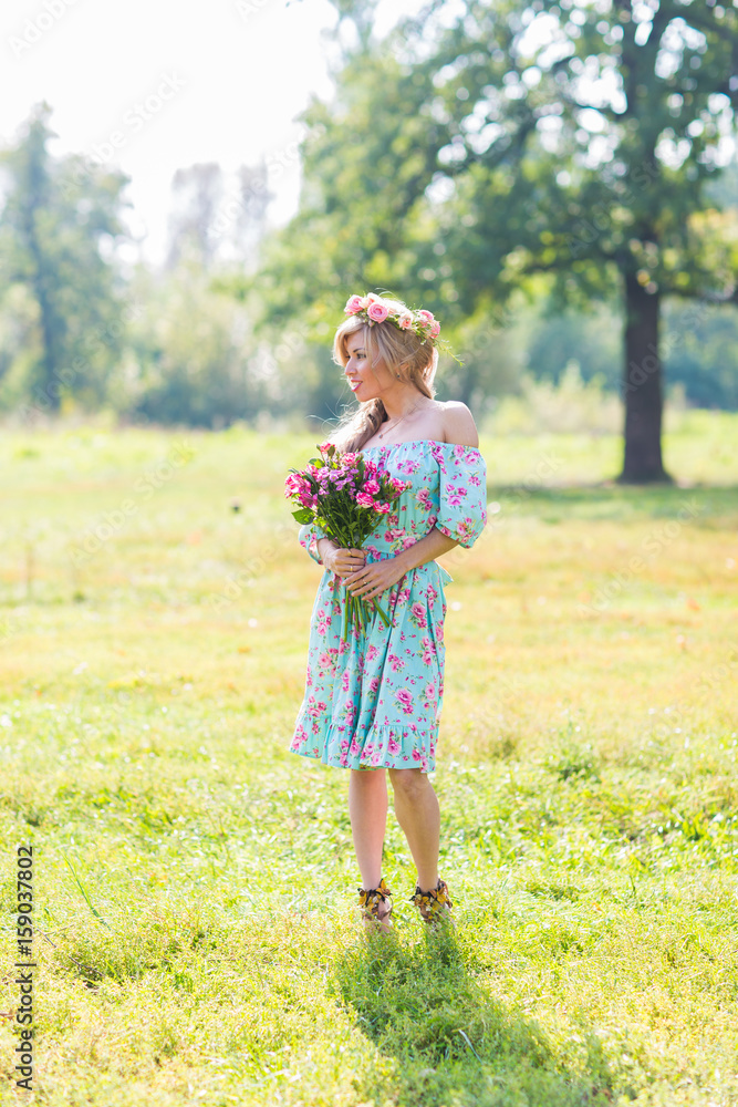 outdoor portrait of a beautiful blonde woman. attractive happy girl in a field with bouquet of flowers. outdoor portrait of a beautiful blonde woman. attractive happy girl in a field with bouquet of flowers.