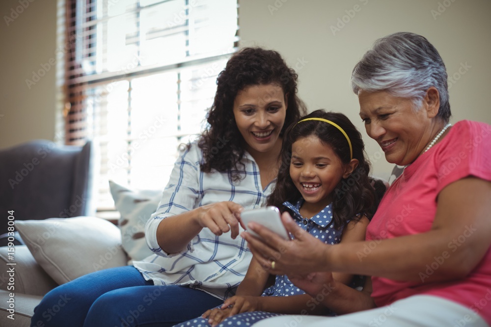 Happy family using mobile phone in living room Happy family using mobile phone in living room