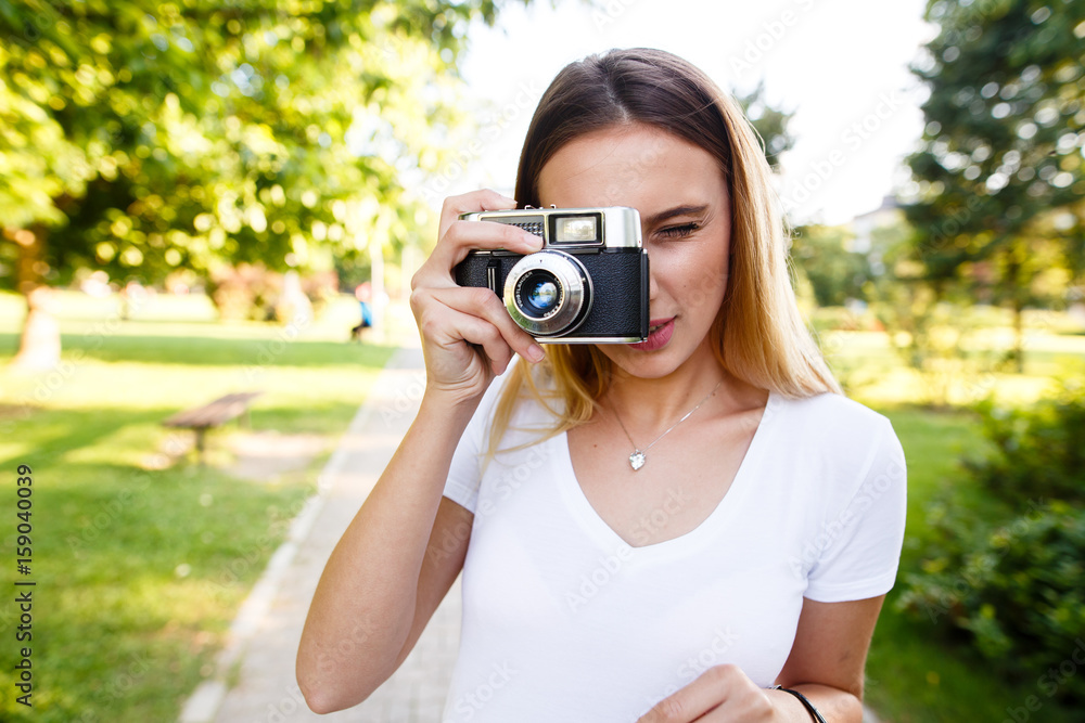 Young girl in park using her free time to take photographs Young girl in park using her free time to take photographs