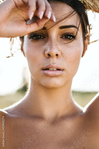 Portrait of a beautiful young woman in sunny fields