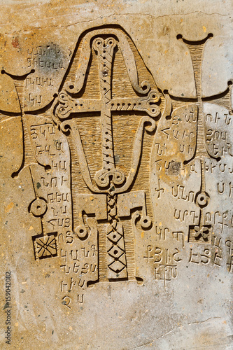 Cross bas-relief on a stone and the alphabet