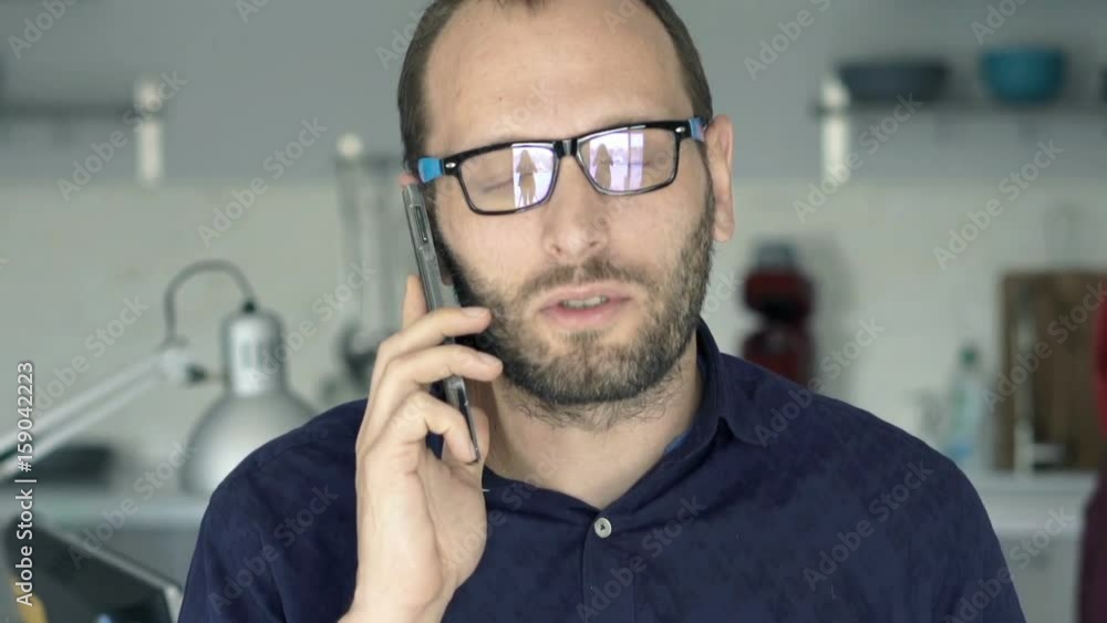 Young man talking on cellphone and drinking beverage at home
Young man talking on cellphone and drinking beverage at home