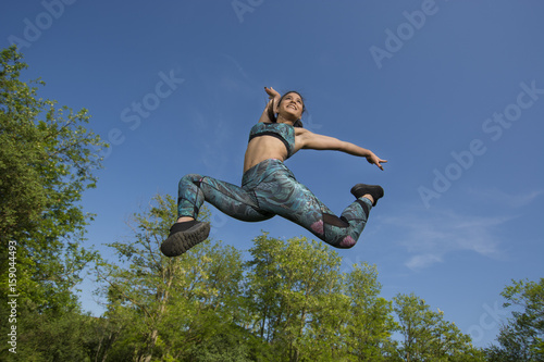 Fit young girl posing for camera during outdoor gym exercises