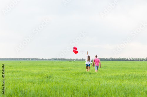 happy couple in love holding red balloon, back view © satura_