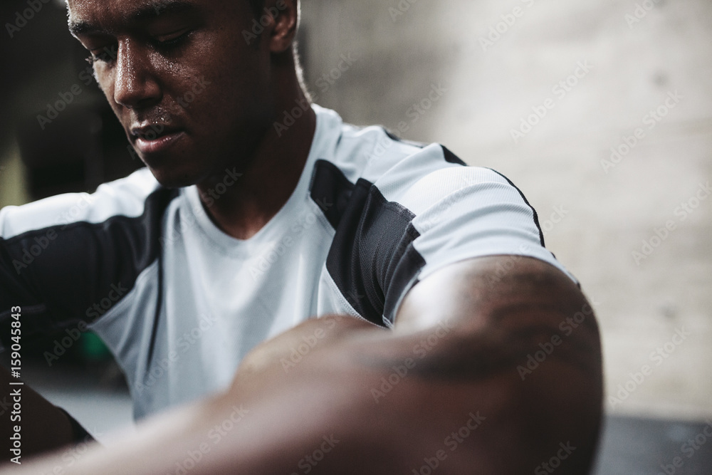 Young, fit black man recovering after training hard in fitness gym Young, fit black man recovering after training hard in fitness gym