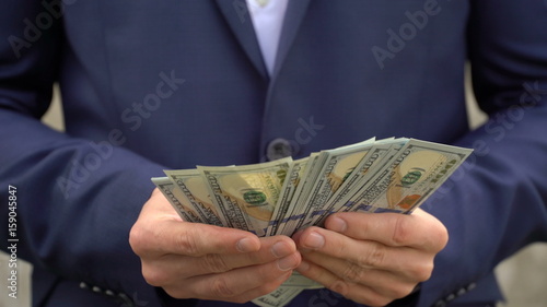 Young businessman shows his money close-up.