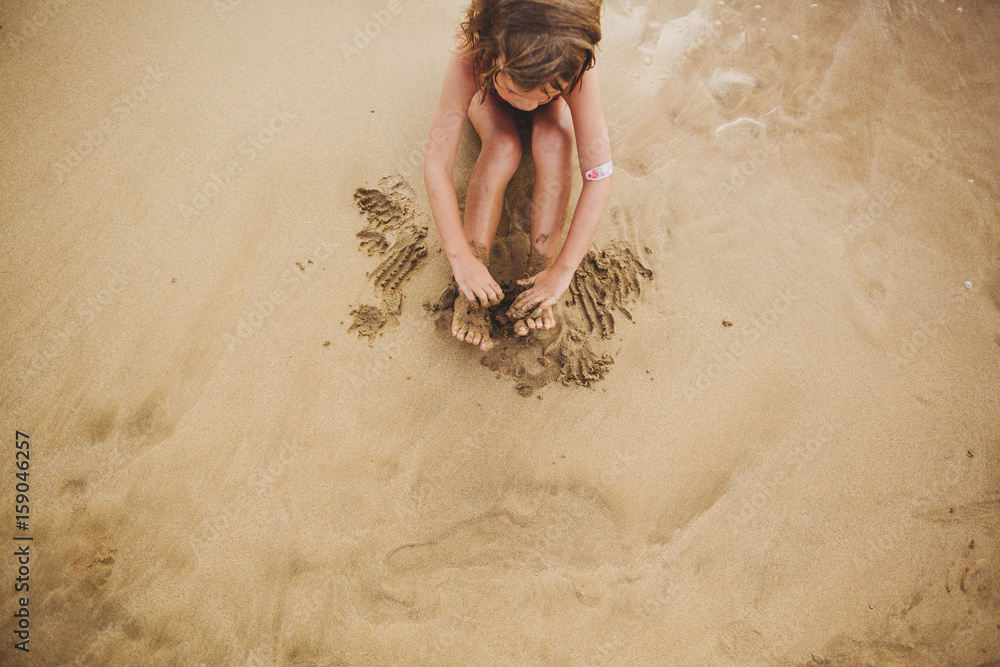 Cute little girl playing alone in sand on tropical beach Stock Photo ...