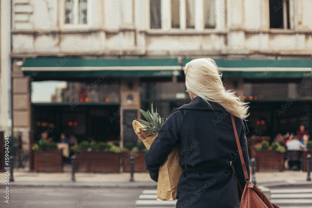© Lumina/Stocksy - Smiling Woman Carrying a Bag With Groceries