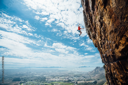 Rock climber falling whilst climbing a mountain cliff photo