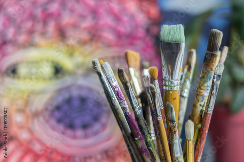 diferent brushes in multicolored paint closeup a