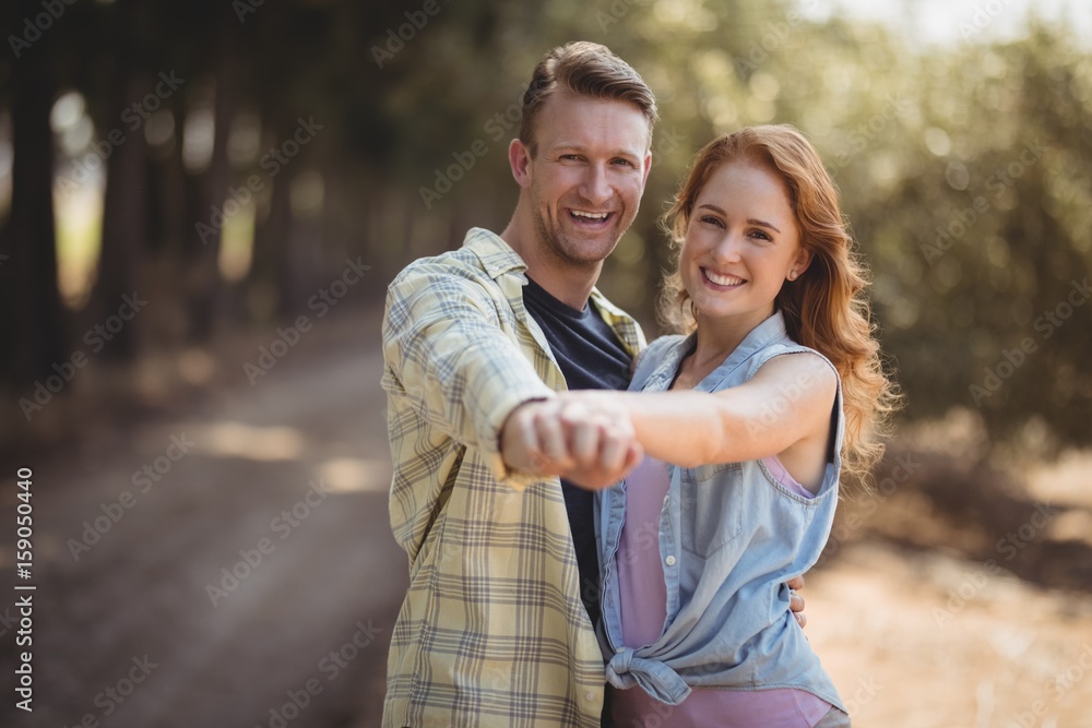 Happy young couple dancing at olive farm during sunny day Happy young couple dancing at olive farm during sunny day