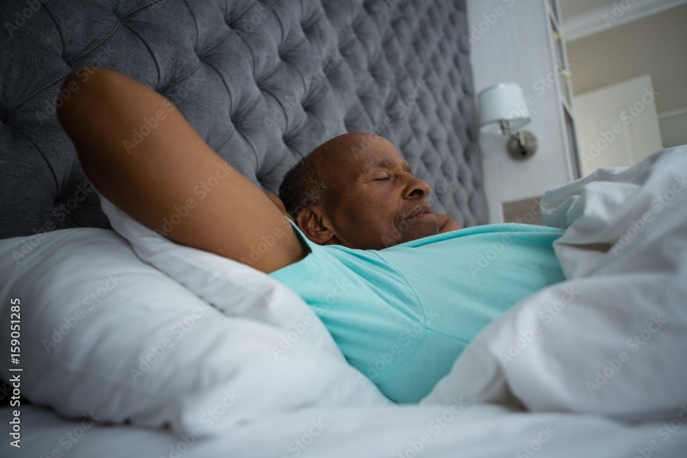 Side view of senior man sleeping on bed at home Side view of senior man sleeping on bed at home