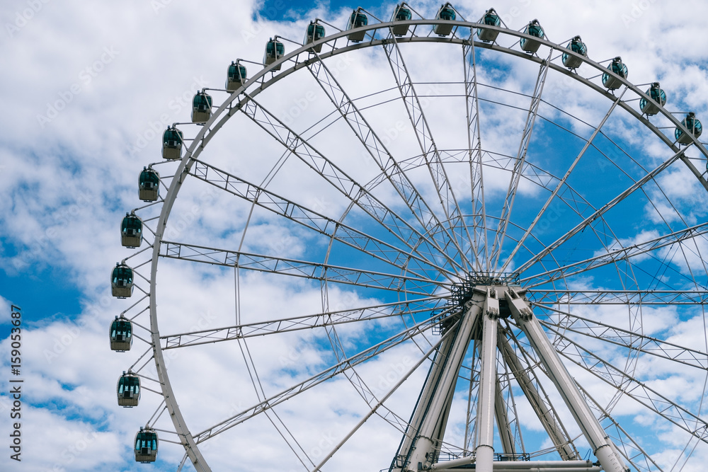 Observation big wheel with the cloudy blue sky in the background