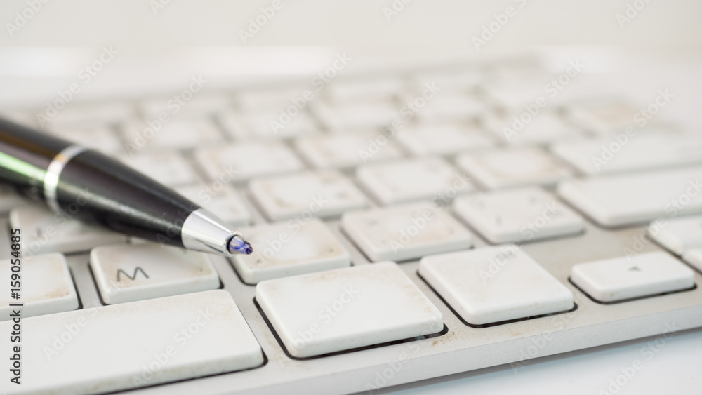 close up pen on keyboard white background close up pen on keyboard white background