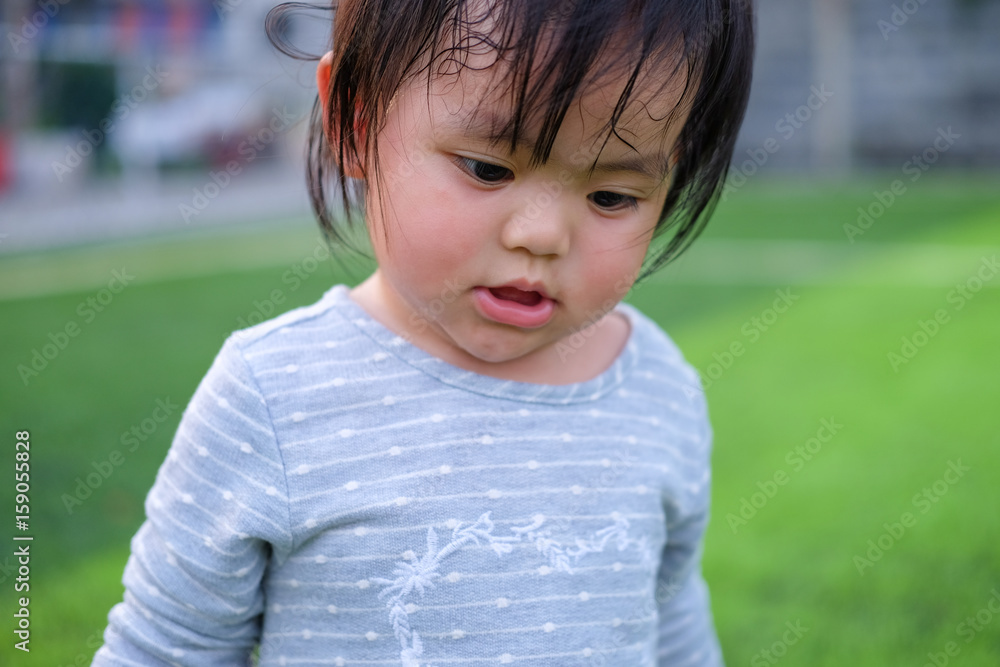 Cute asian baby girl playing on football field. Portrait of Asian beautiful baby girl of 1 year and 3 months old. Cute asian baby girl playing on football field. Portrait of Asian beautiful baby girl of 1 year and 3 months old.