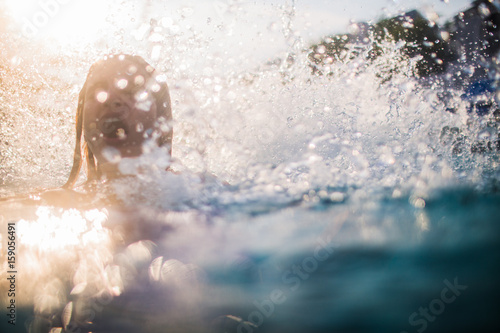 Young woman emerges from the water gasping for air