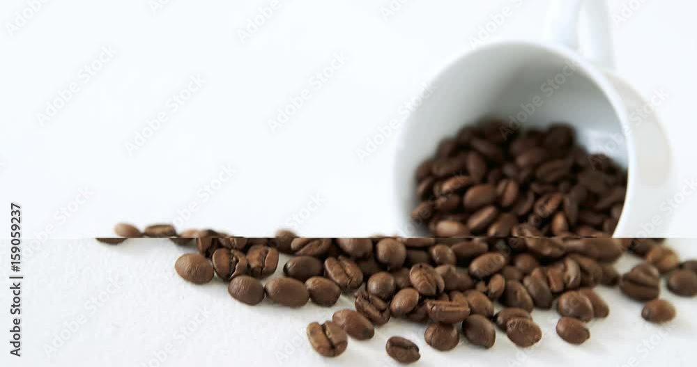 Roasted coffee beans spilling out of cup Roasted coffee beans spilling out of cup