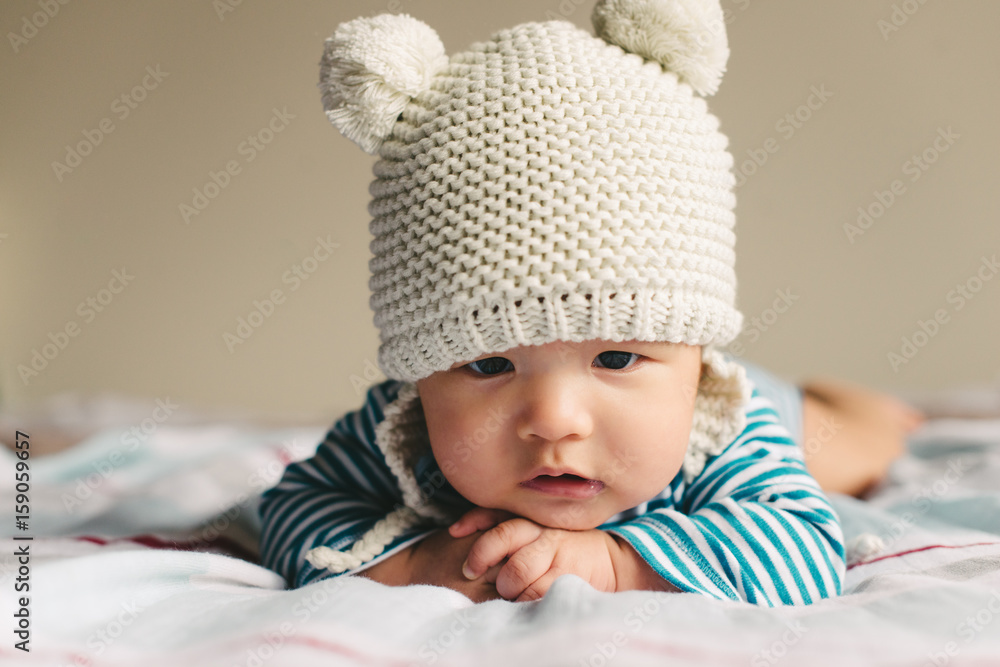 Newborn baby wearing a cute hat, laying on belly Newborn baby wearing a cute hat, laying on belly