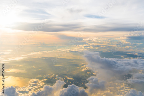 White clouds and blue sky at sunrise, view from above air plane window.
