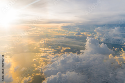 White clouds and blue sky at sunrise, view from above air plane window.