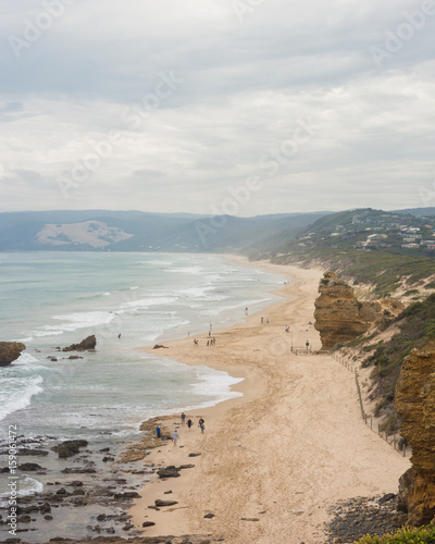 Long sandy beach with cliffs and gentle waves