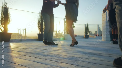 Young couples dancing salsa, bachata, latin dance on open air party in evening time. No face, only legs. 4k