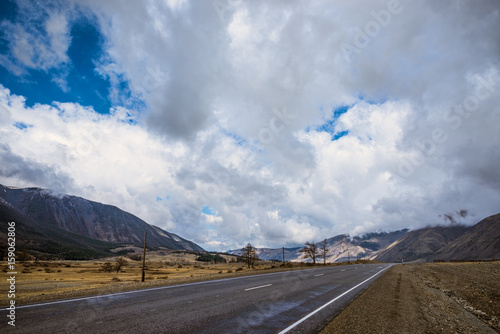 panoramic view of plain with road at root of mountains 