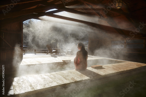 Woman relaxing at spa with hot springs photo
