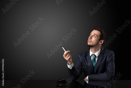 Businessman holding cigarette.