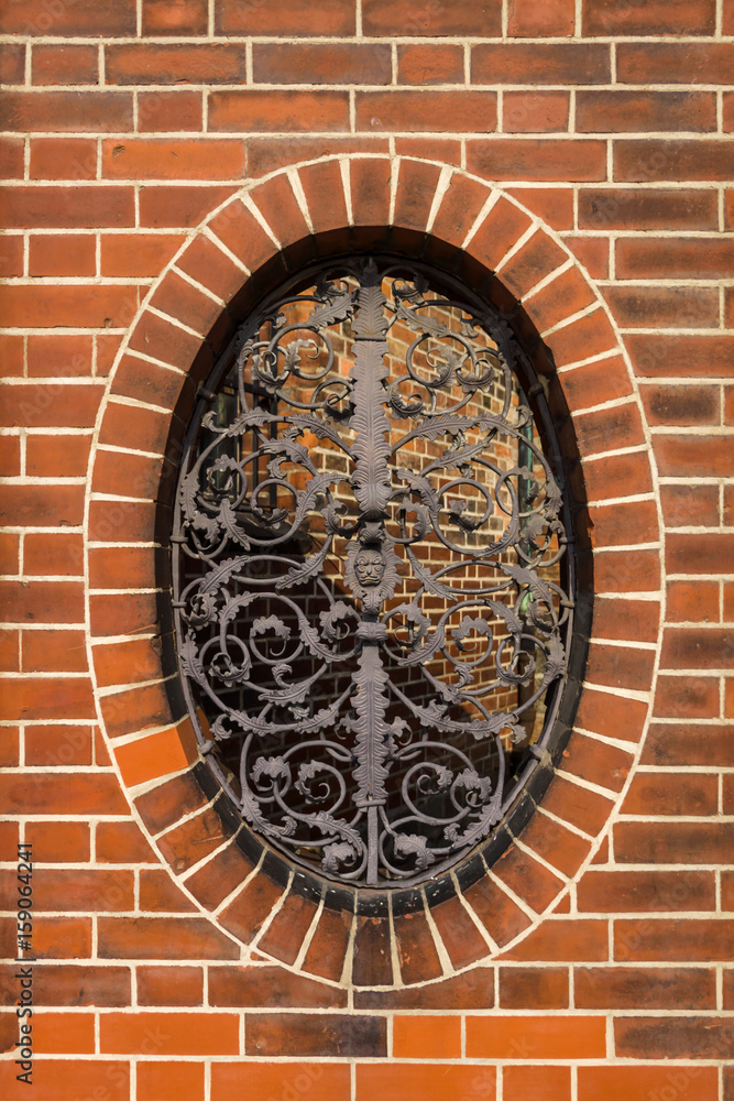 Wrought iron grille with floral patterns on the oval window.