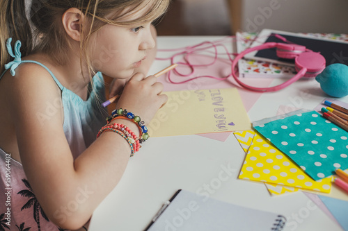 Cute Blonde Girl Writing at Her Desk photo