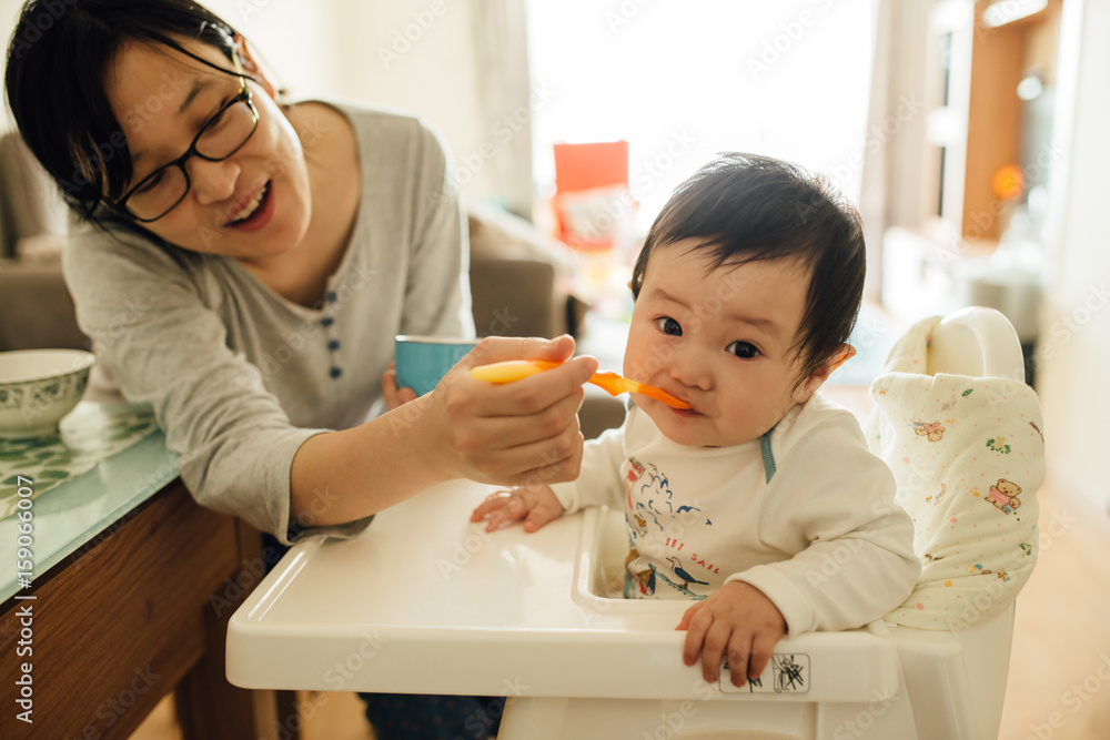 Chinese young mother feeding her littler baby boy Chinese young mother feeding her littler baby boy