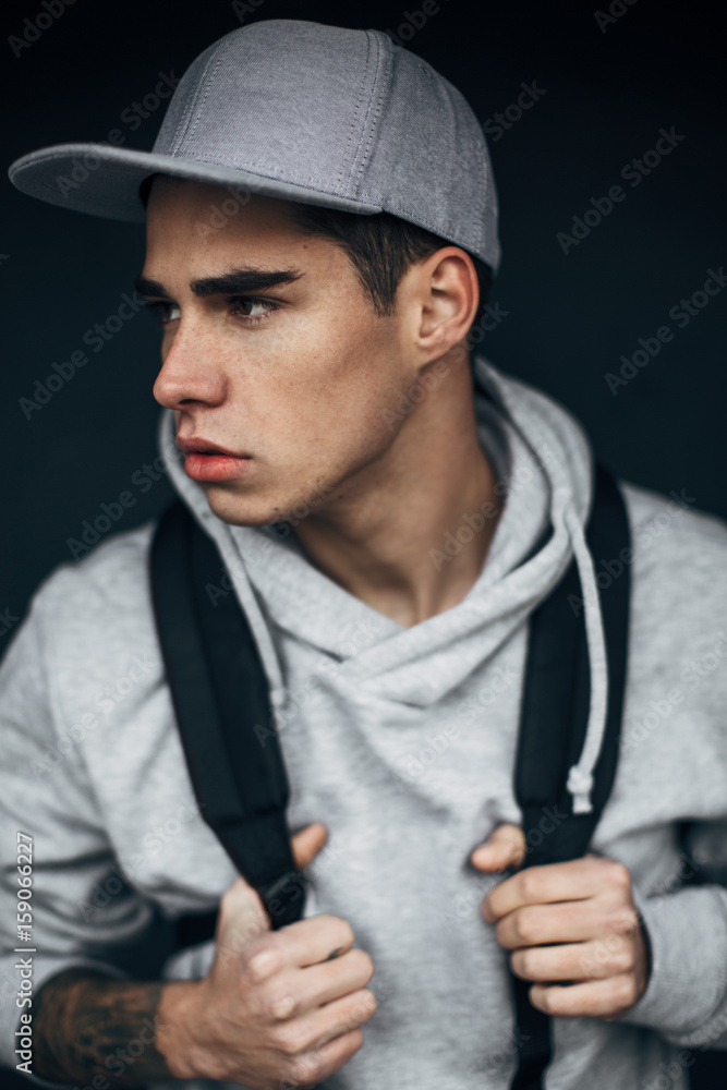 Portrait of a young modern man standing in front of black background Portrait of a young modern man standing in front of black background
