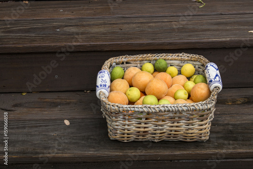Wallpaper Mural Apricot, oranges and limes in wicker basket with ceramic hand painted handles   Torontodigital.ca