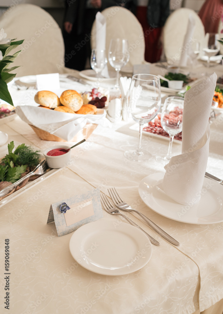 Blank card for guests near white empty plate on dinner table for wedding banquet, free space for text