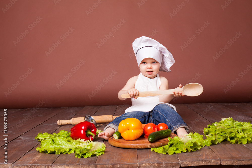 the boy chef with a wooden spoon, carrots, peppers, tomatoes, lettuce, cucumber the boy chef with a wooden spoon, carrots, peppers, tomatoes, lettuce, cucumber
