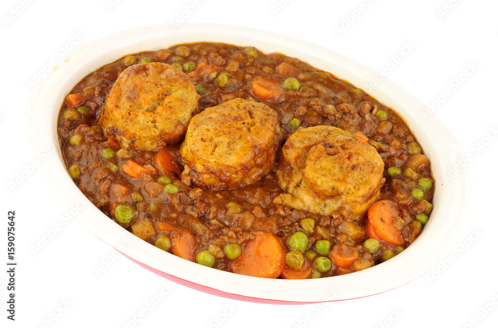 Minced beef casserole with dumplings in an oven proof dish isolated on a white background