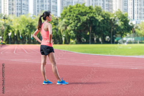 Young woman ready for sun in red track stadium