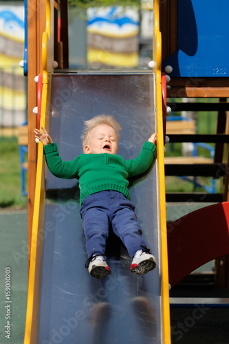 One year old baby boy toddler wearing green sweater at playground © haveseen