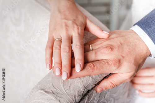 Newlywed couple hands with wedding rings