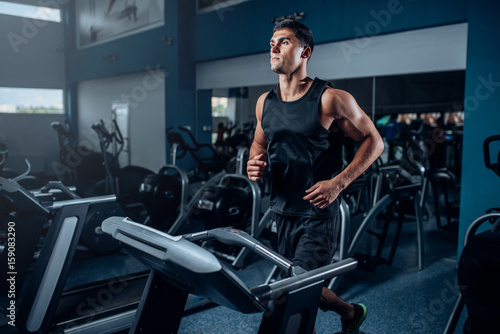 Male athlete workout on running exercise machine photo