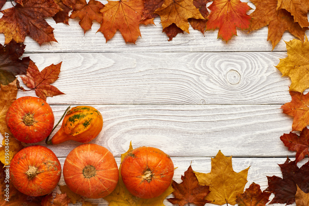 Autumn leaves and pumpkins over old wooden background Autumn leaves and pumpkins over old wooden background