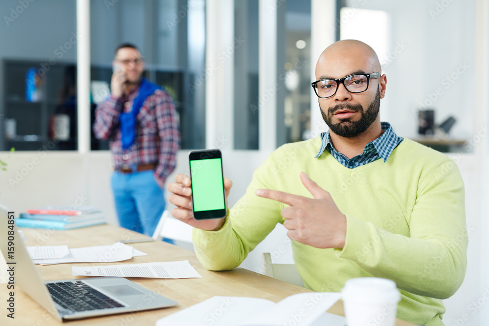 Confident man pointing at smartphone screen in his hand Confident man pointing at smartphone screen in his hand