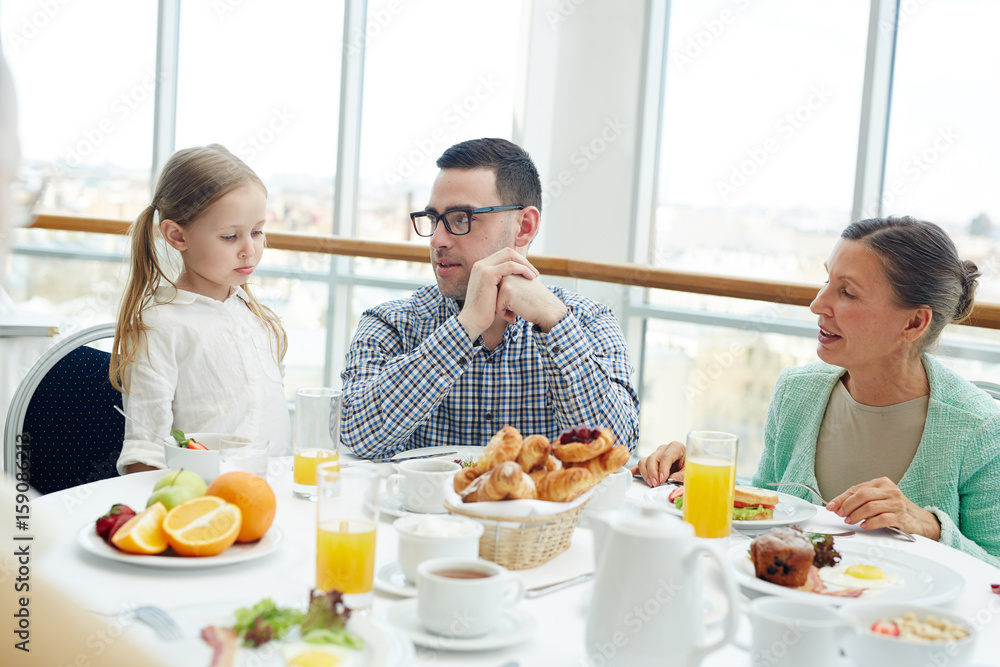 Cute girl, her father and grandmother having breakfast Cute girl, her father and grandmother having breakfast