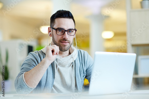 Modern and mobile man with earphones and laptop