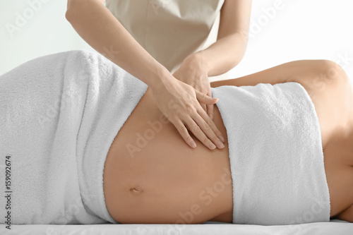 Fotografie Young beautiful pregnant woman having massage in spa salon