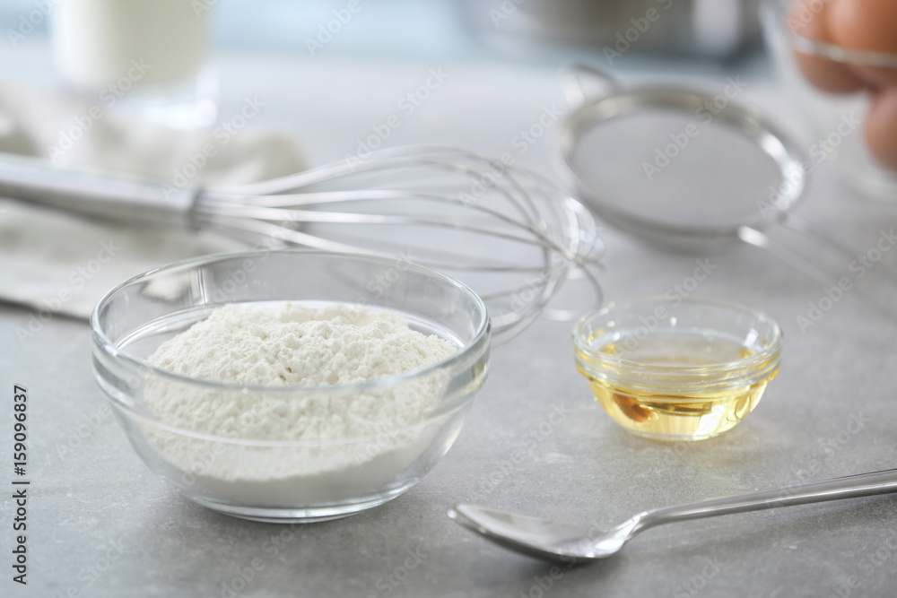 Glass bowl with wheat flour on kitchen table Glass bowl with wheat flour on kitchen table